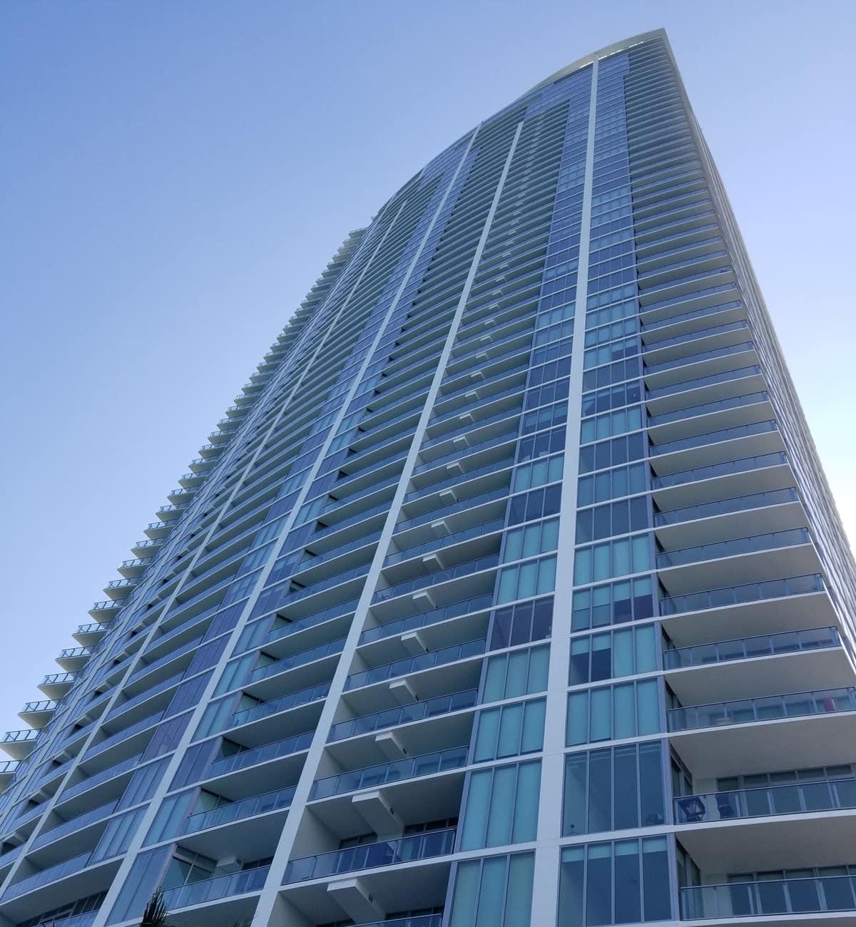 Slender glass residential tower against a blue sky