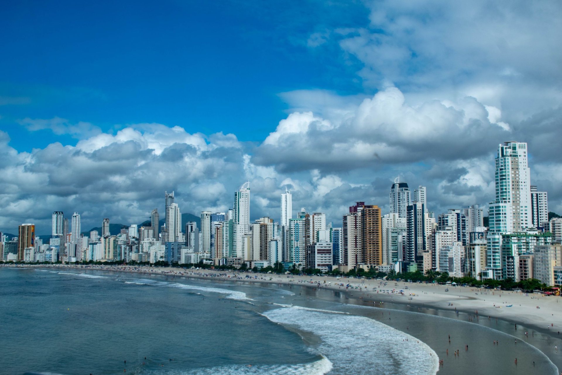 High-rise towers along a beachfront under a blue sky
