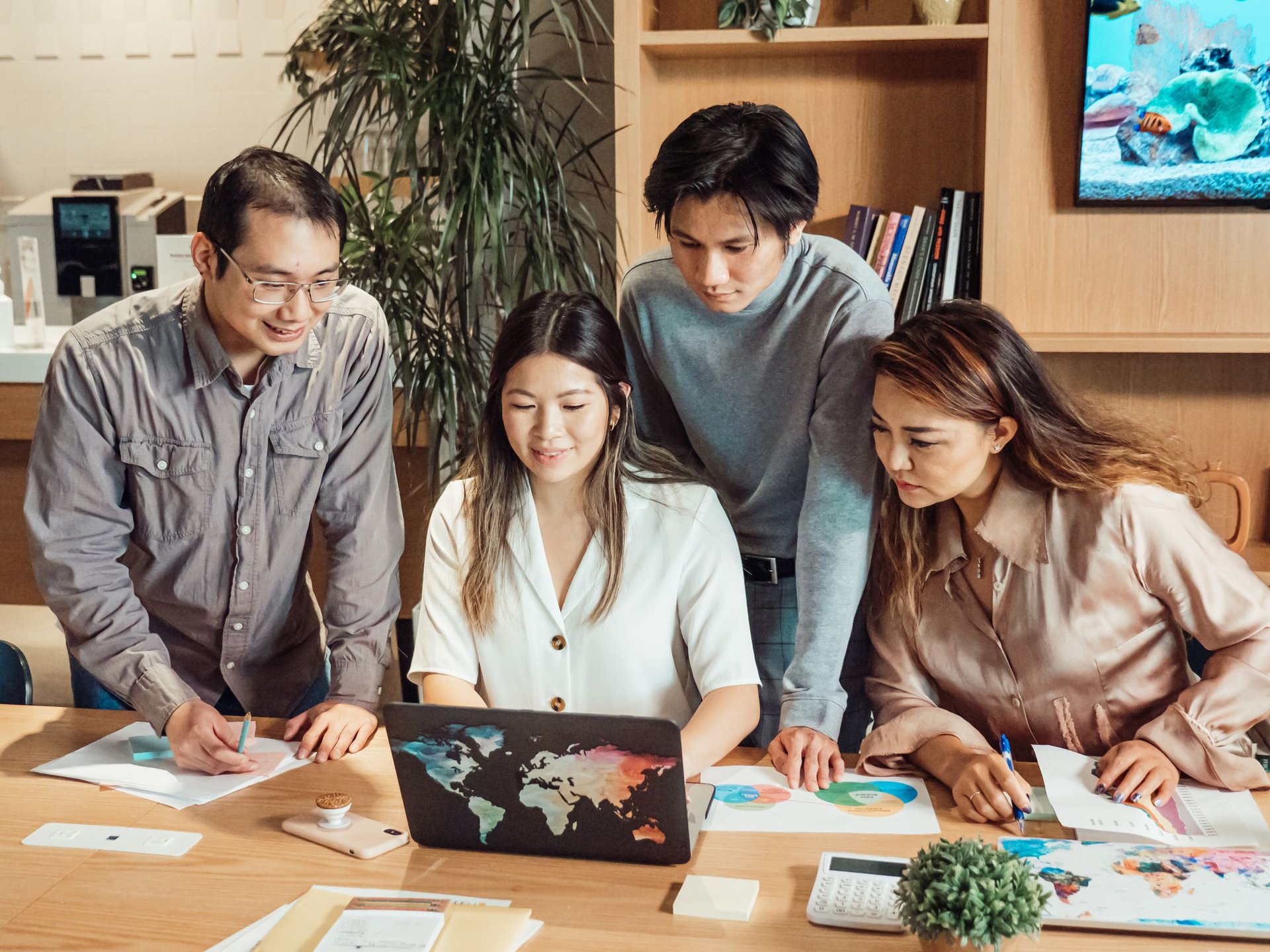 Sales team planning together around a laptop